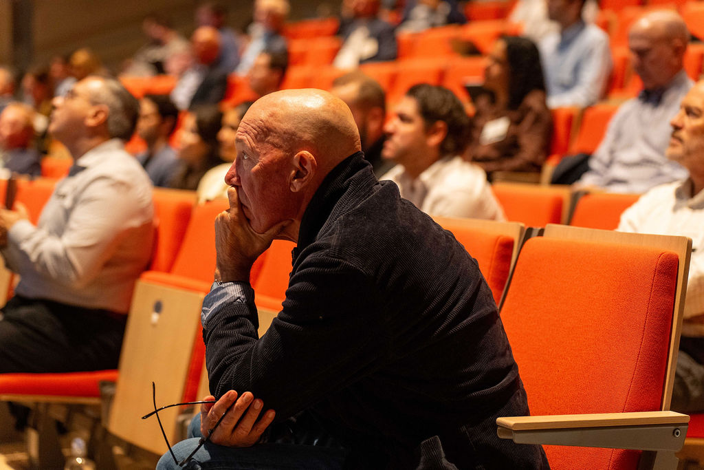 Attendee listening intently from the audience